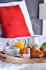 Breakfast on tray in bed in hotel room
