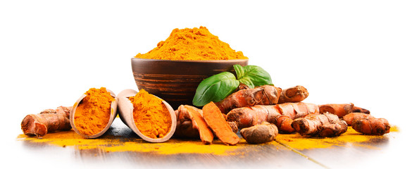 Bowl of turmeric powder over white background © monticellllo