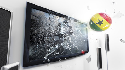 Soccer ball with the flag of Ghana kicked through a shattering tv screen.(3D rendering series)