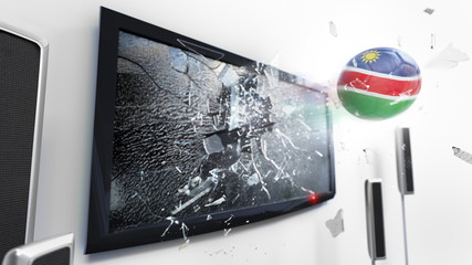 Soccer ball with the flag of Namibia kicked through a shattering tv screen.(3D rendering series)