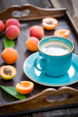 Obraz na płótnie Canvas Closeup of fresh coffee and plums on wooden tray