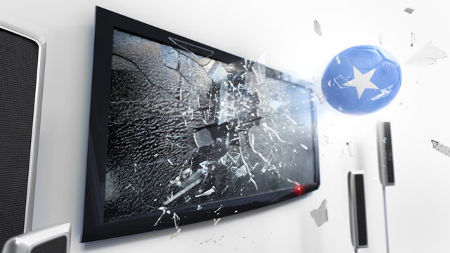 Soccer ball with the flag of Somalia kicked through a shattering tv screen.(3D rendering series)