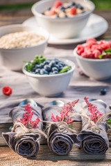 Napkins, cutlery, raspberries and blueberries on old wooden table