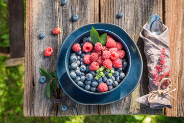 Top view of raspberries and blueberries in blue bowl
