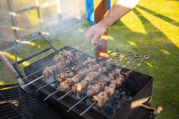 Shish kebab on a skewer getting ready on a barbecue grill