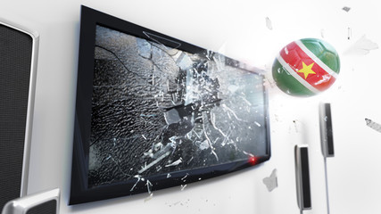 Soccer ball with the flag of Suriname kicked through a shattering tv screen.(3D rendering series)