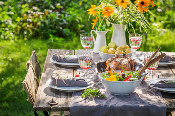 Dinner with salad and chicken served in summer garden