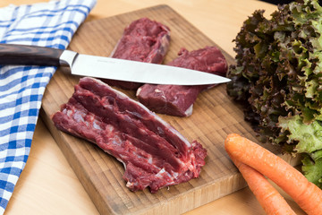 saddle of venison on wooden board