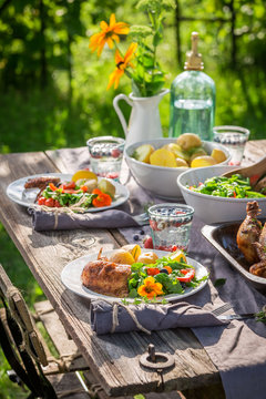 Dinner with chicken and vegetables served in summer garden