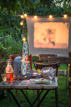 Summer cinema with retro projector in the evening in garden