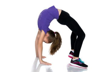 The little gymnast performs a bridge.