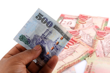 Saudi man counting thousands Saudi Riyal isolated on white background