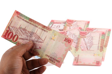 Saudi man counting thousands Saudi Riyal isolated on white background