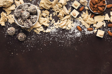 Obraz na płótnie Canvas Crushed white chocolate pieces and truffles on dark background