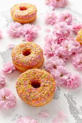 Sweet pink fresh Donut decorated with japanese Flowering Cherry Tree flower