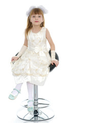 Little girl is sitting on a chair