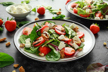 Summer Fruit Strawberry, spinach Salad with walnut, feta cheese balsamic vinegar, kale. in a plate. concepts health food