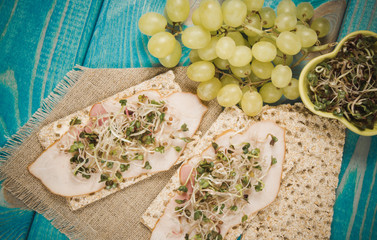 Healthy diet. Sandwiches with ham and broccoli sprouts on crisp bread.