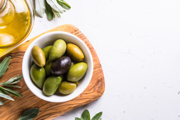 Olives and olive oil on white.