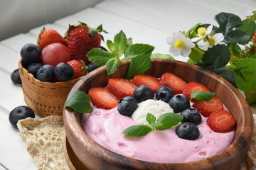 Ideas for healthy summer breakfast op dessert. Smoothies in bowls with strawberry, blueberry berry. With oatmeal, fresh berries.