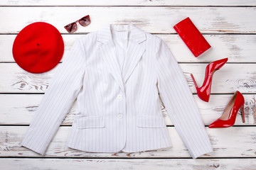 Set of female white blazer and red accessories. Flat lay women classic jacket and red heels. Red beret and red purse, female clothes. Woman fashion and style.