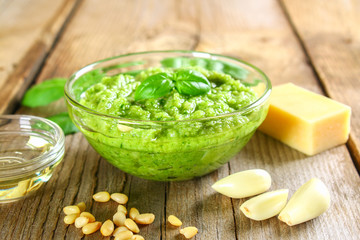 Homemade pesto sauce. Ingredients. Cheese, garlic, basil, pine nuts, olive oil on an old wooden table.