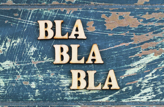 Bla, bla, bla written with wooden letters on rustic surface
