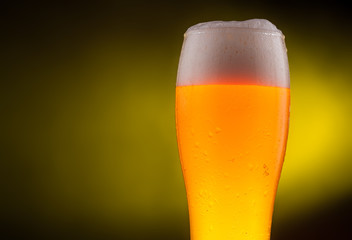 Cold light Beer in a glass with water drops.