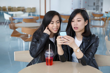 Two happy girls Asian girlfriends make a joint selfie.