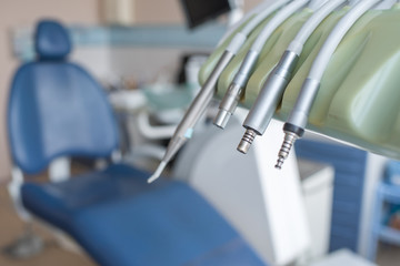 Fototapeta premium Close-up of various dental machines and tools with metal surface on stand of dental chair. 
