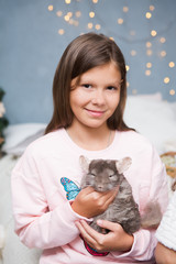 Cute girl with funny chinchilla in the home