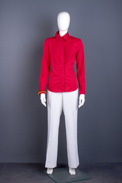 Full length mannequin in red women shirt. Female red cotton blouse and white trousers. Feminine elegant style.
