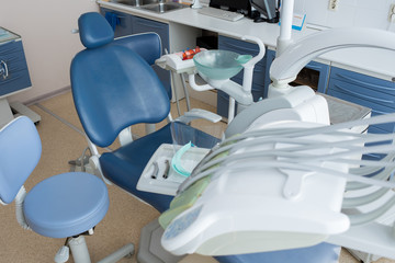 View of chair and apparatus with tools for working process of dentist in daylight. 