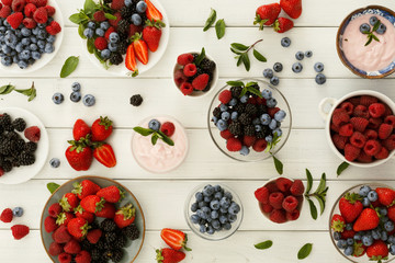 Healthy breakfast with berries and yogurt on white wooden table