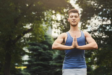 Meditating man with praying hands outdoors