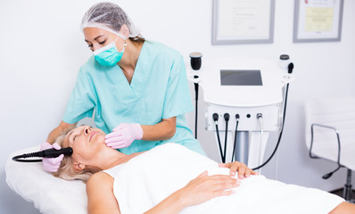 Female cosmetologist during procedure cryolipolyse