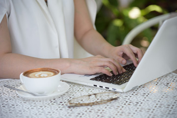 Fototapeta premium businesswoman typing a notebook in the garden