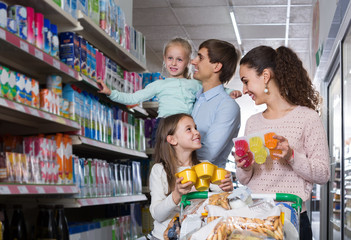 Naklejka premium customers with children selecting sweet dairy products in hypermarket