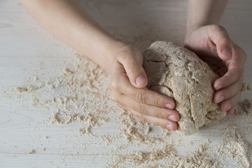 Child hands on white background molds, rolls the dough pizza