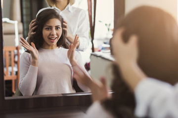 Happy customer looking in mirror after haircut