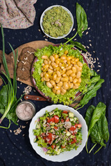 Fototapeta na wymiar White beans cooked with herbs, onion, garlic and spices. Served with salad leaves and vegetables. Raw vegan vegetarian healthy food. Farm organic product