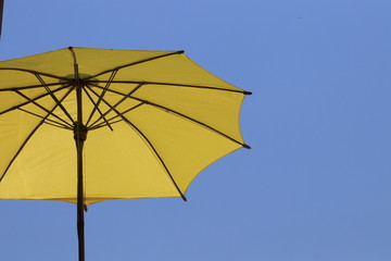 Close up transparency big yellow umbrella and blue sky