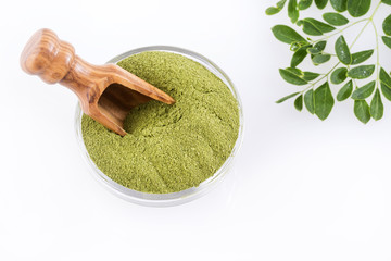Moringa powder and leaves. White background - Moringa oleifera