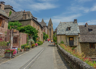 Fototapeta na wymiar Conques, Midi Pyrenees, France - July 31, 2017: View of Sainte Foy Cathedral at the end of the main street of Conques