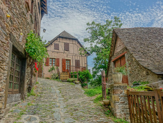 Conques, Midi Pyrenees, France - July 31, 2017: Typical narrow stone street in the village of...