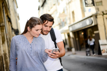 cheerful young couple on a cultural weekend city trip discovering together historical european city in summer