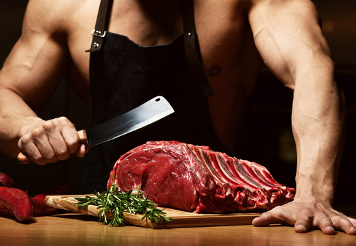 Strong sport man prepare cook beef steak ribs on dark kitchen healthy eating diet concept 
