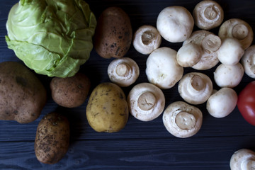 Champignons, potatoes and cabbage on a cuisine table close up.