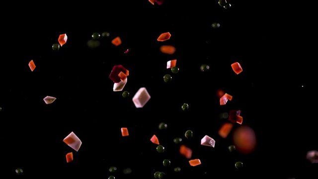 A sliced mix of vegetables fall slowly down.