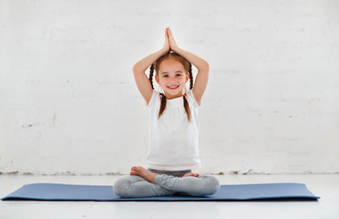 child girl doing yoga and gymnastics in gym
